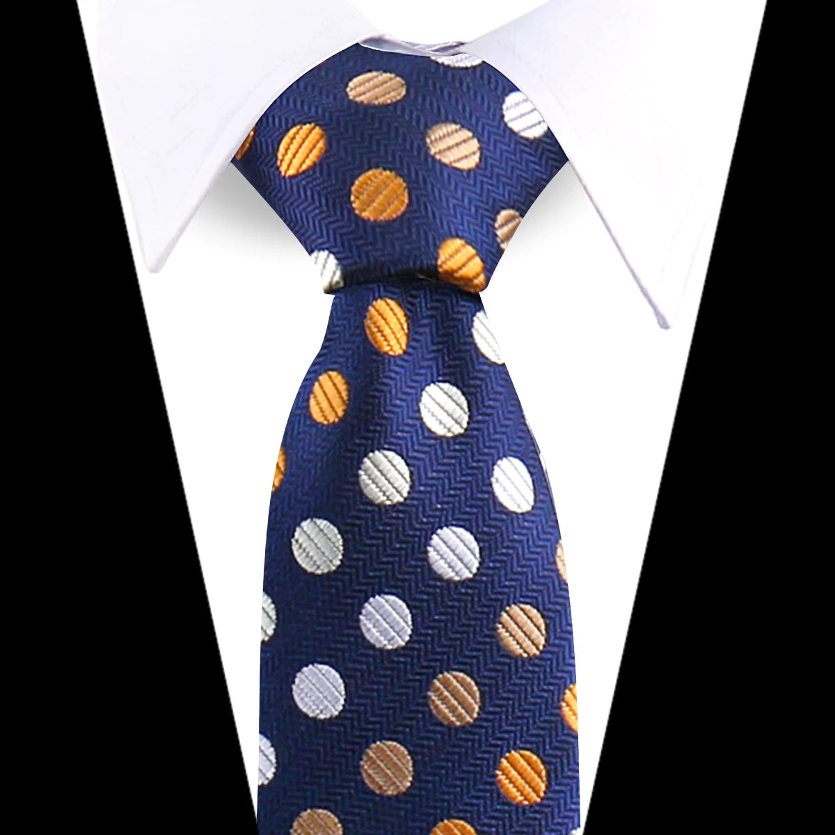 A navy blue silk necktie with gold and white polka dots worn under a white dress shirt.