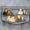 Un ensemble de broches à poisson émaillé avec des personnages de Twilight, dans des tons or et argent, épinglés sur du tissu 