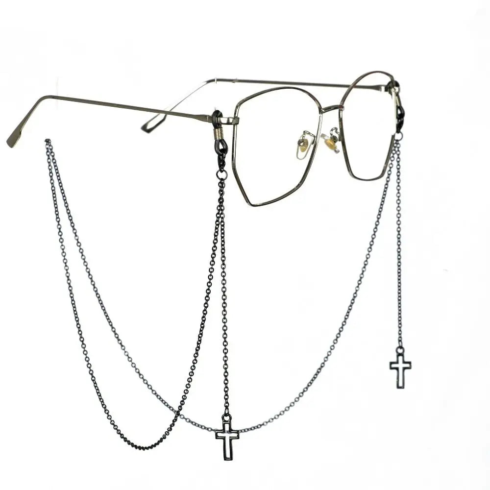 A pair of clear-framed eyeglasses with a delicate chain lanyard and cross charm.