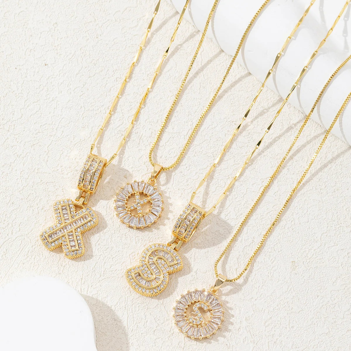 A set of gold-toned necklaces featuring CZ crystal pendants shaped like the letters A, Z, and S.
