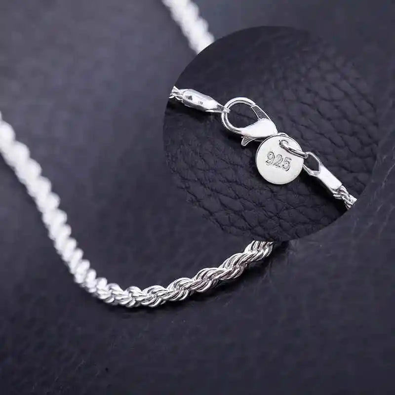A silver rope charm necklace with a 925 stamped charm is displayed against a black background.