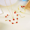 A set of five gold-colored bracelets featuring red enamel plum blossoms displayed on a light background.