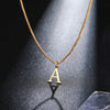 A gold initial letter necklace hanging against a dark, reflective surface.