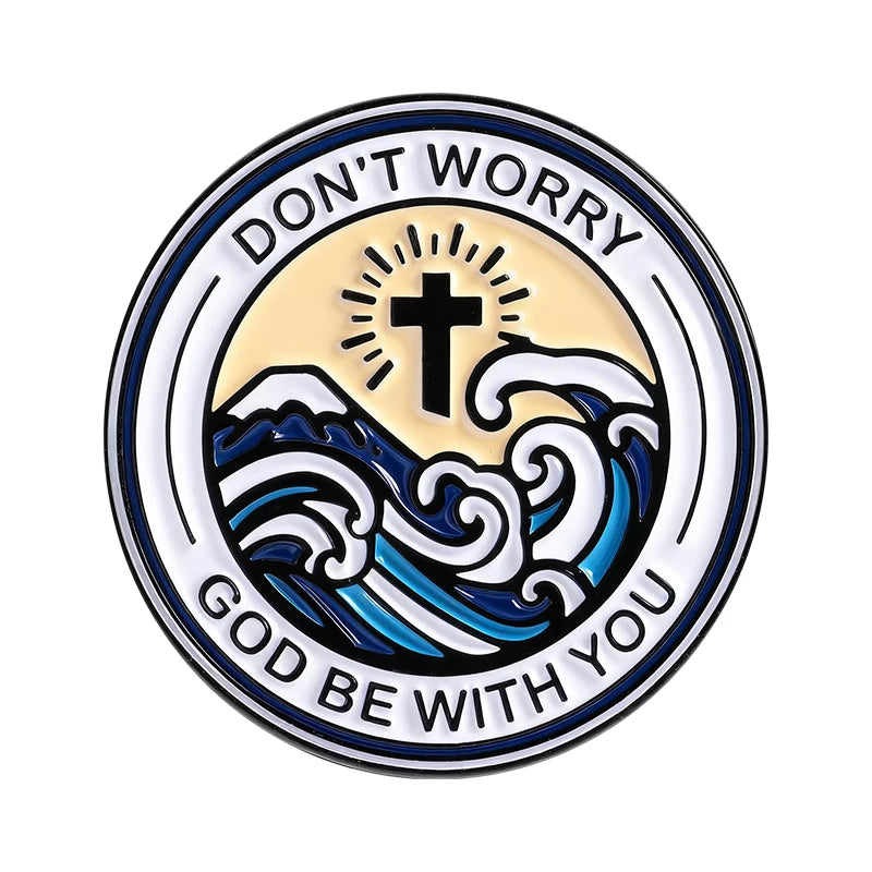 Broche émaillée avec le texte « Don't Worry God Be With You » entourant une silhouette d'onde et une croix.