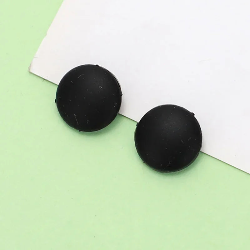 Two black silicone eyeglass grips resting on a white background.