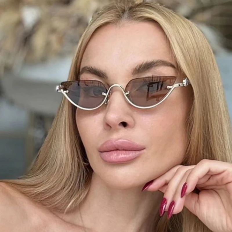 Primer plano de una mujer usando gafas de cat-eye metálicas retro con detalles dorados.