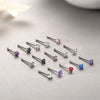 A collection of surgical stainless steel nose piercing studs featuring various colored gemstones like pink, purple, and blue.