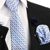 Blasc-weiß gestreiftes Halstuch vor weißem Hemd und schwarzem Sakko mit dunkelblauer Blumenaccessoire