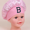 Pink satin sleep cap for kids with a black letter B embroidered on the front