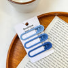 A set of vintage frosted geometry hair clips in blue and white are displayed on a wooden tray.