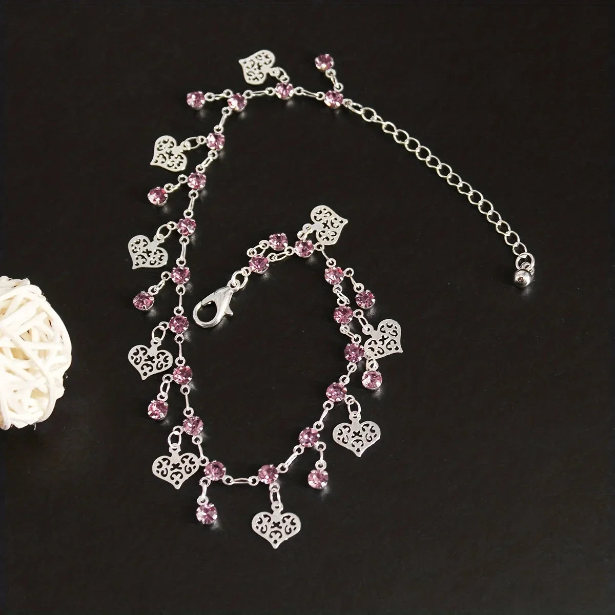 Silver stainless steel anklet featuring small pink and clear rhinestone pendants.