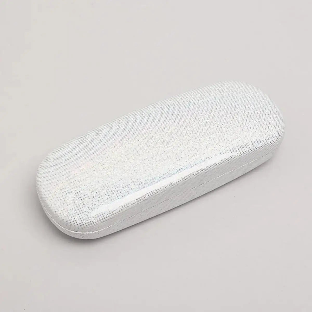 Une petite boîte de rangement ovale et blanche recouverte de sequins brillants.