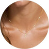A close-up of a gold plated alphabet initial necklace with the letter J worn around the neck.