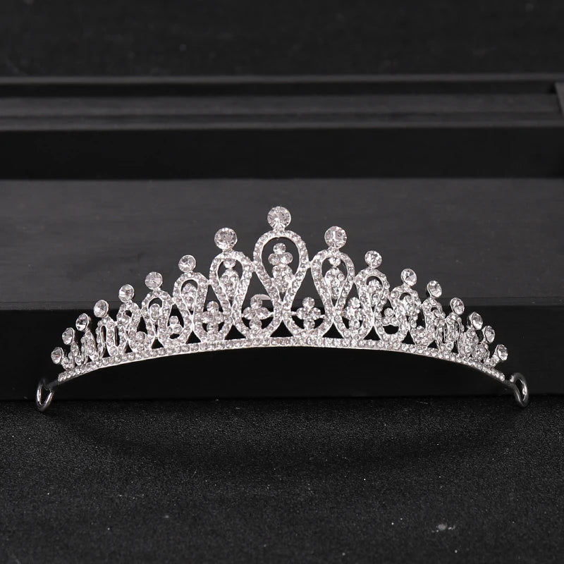 A sparkling crystal rhinestone bridal tiara headpiece displayed on a dark surface.