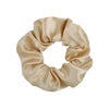 A beige satin fabric scrunchie tied in a gathered, ruched style.