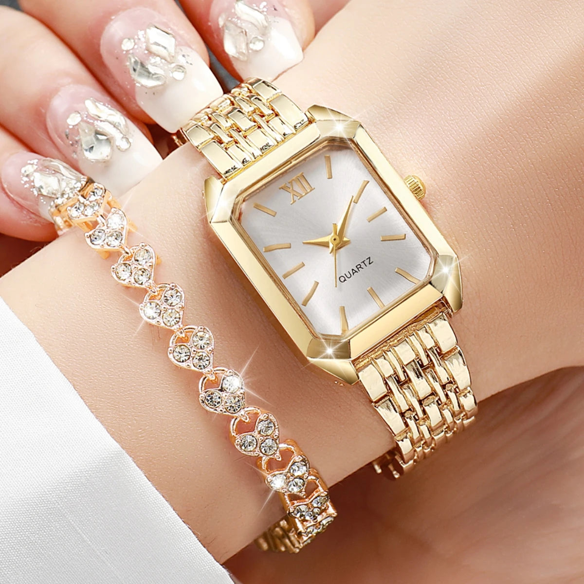 Une montre-bracelet en quartz ton or et un bracelet assorti en strass sur le poignet d'une personne.