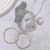 Silberes Quarzkristall-Armbandset für Damen mit Uhr, Halskette und Ringe auf weißem Marmor