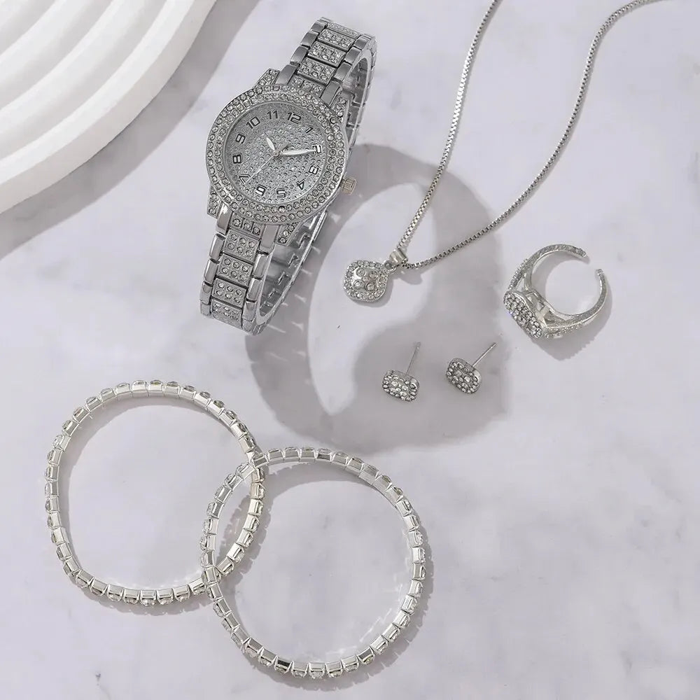 Silberes Quarzkristall-Armbandset für Damen mit Uhr, Halskette und Ringe auf weißem Marmor