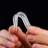 A pair of clear, flexible invisible ring sizer tools being held by a person.
