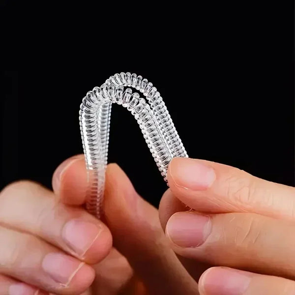 A pair of clear, flexible invisible ring sizer tools being held by a person.
