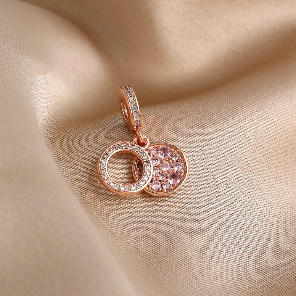 Rose gold charm pendant featuring two interlocking circular charms with pink stones