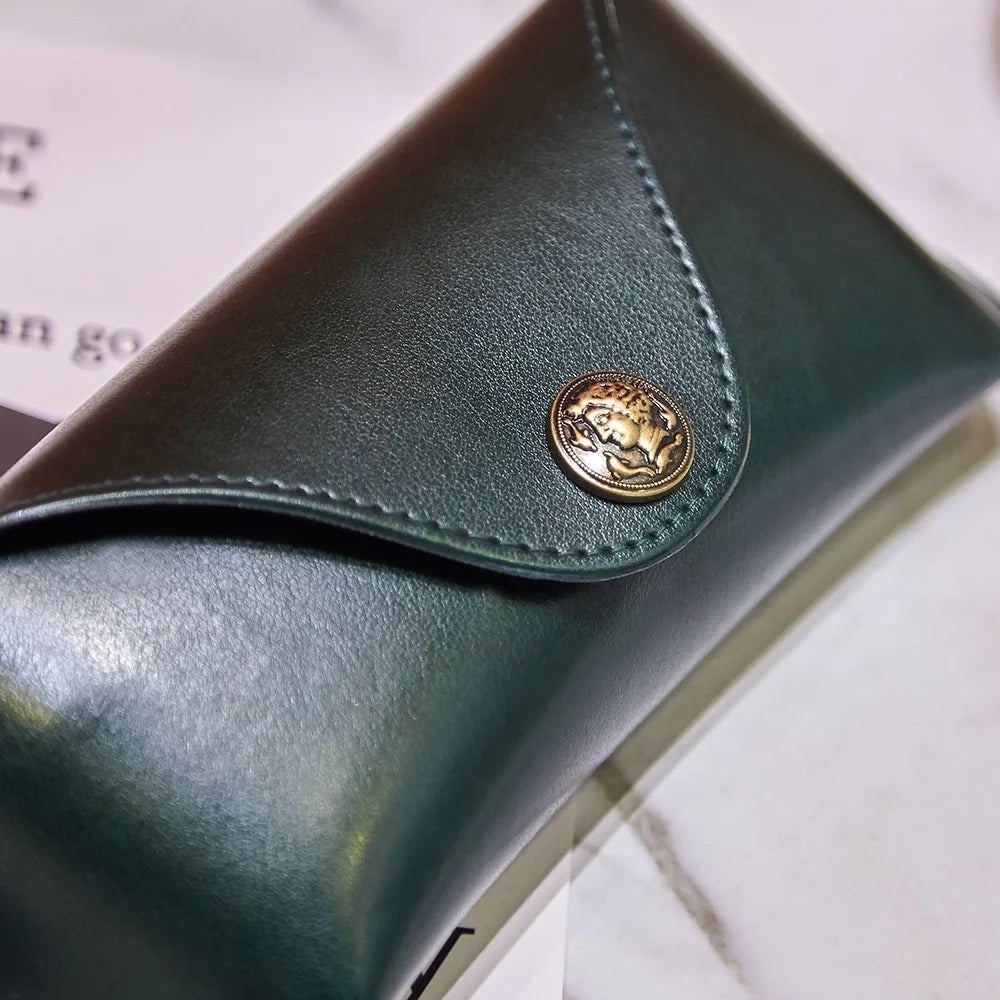 Estuche suave retro verde oscuro de PU para gafas y joyas, con un emblema dorado.