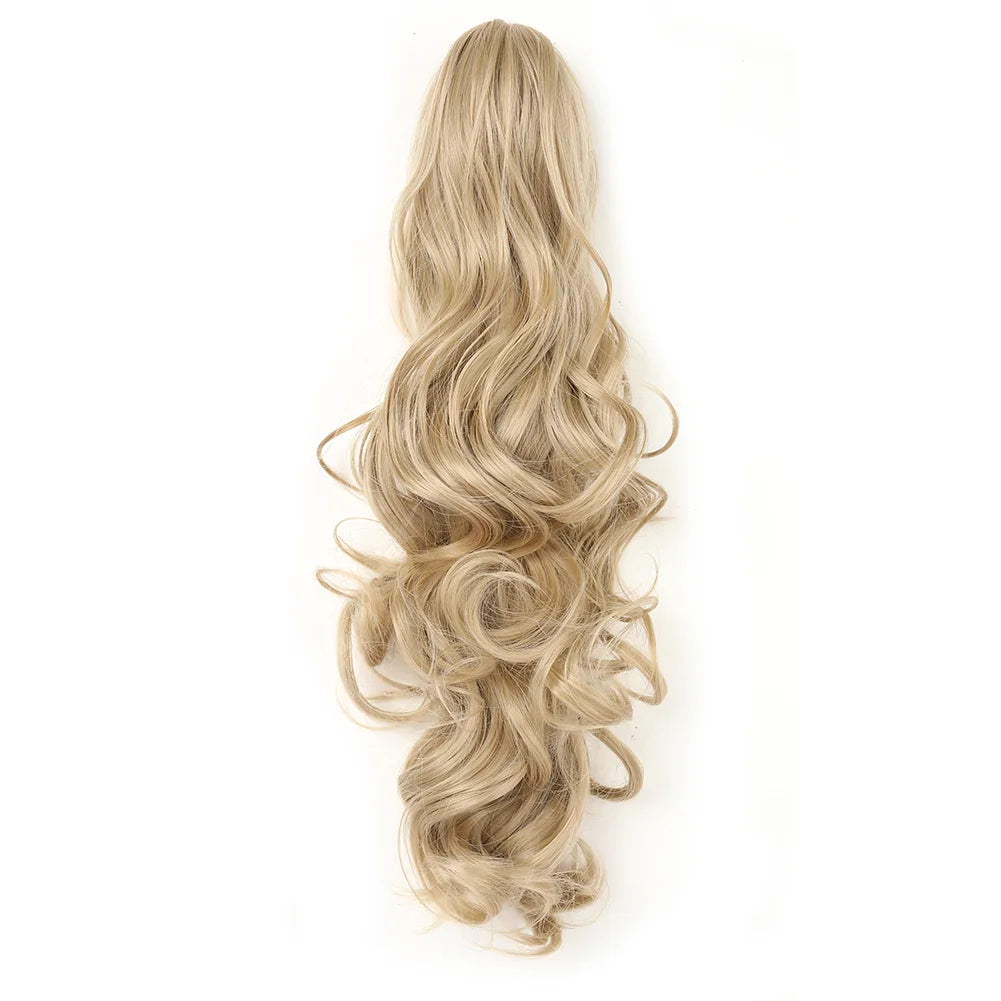 Una pieza de cabello rubio largo, peinado en rizos sueltos y recogido con un clip de uñas.