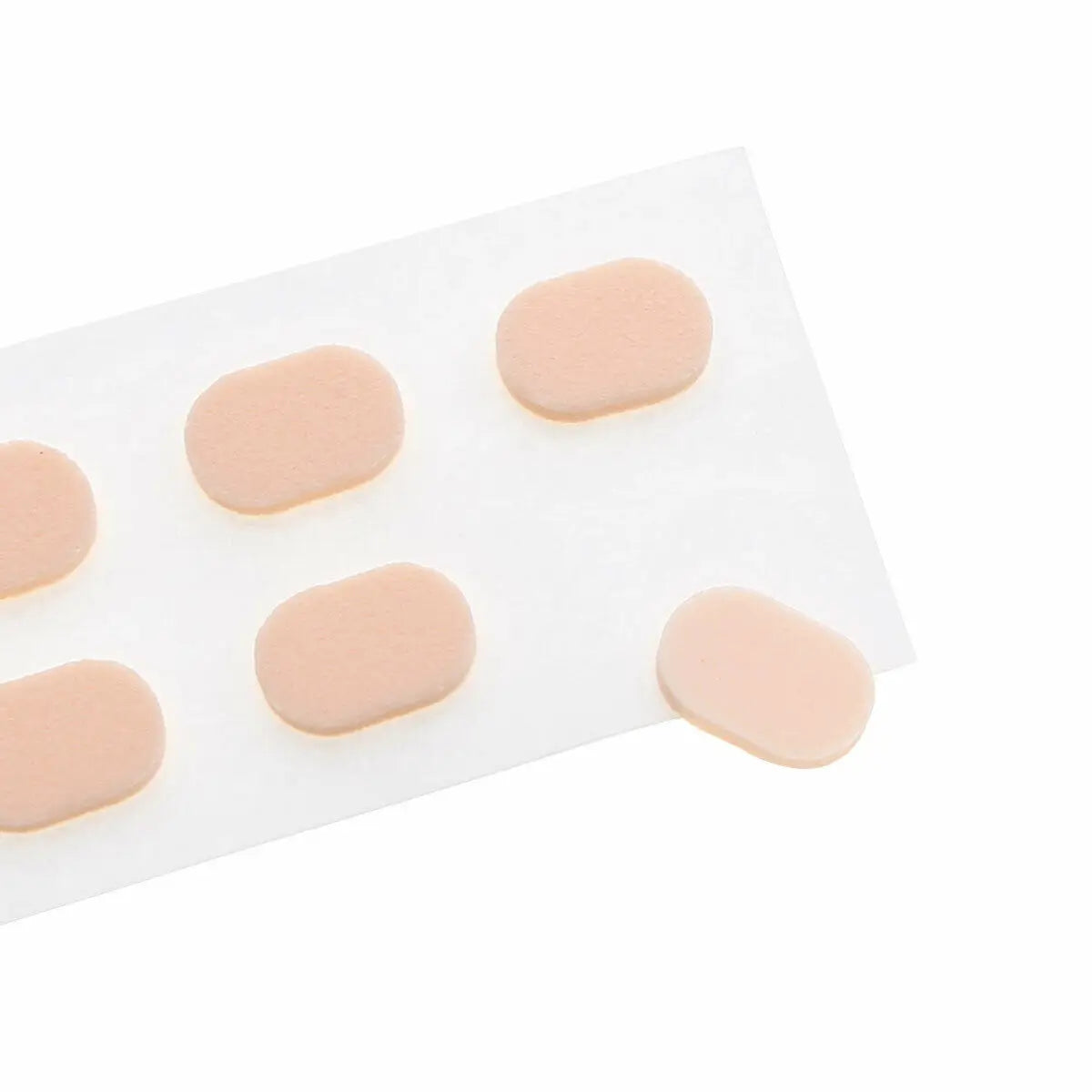 Un cacheté blanc avec cinq embouts de nez ovales en plastique souple et autocollants de couleur chair.