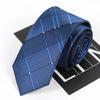A dark blue striped skinny necktie folded on a black surface.