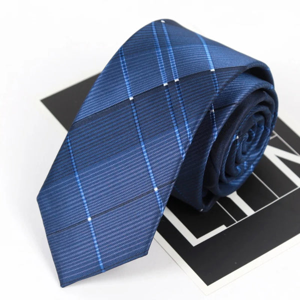 A dark blue striped skinny necktie folded on a black surface.
