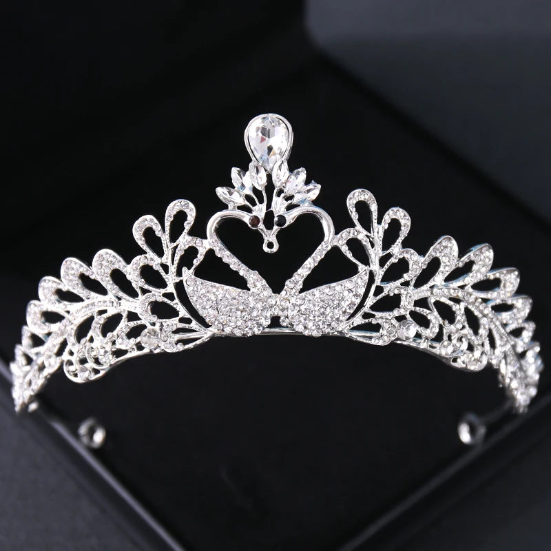 Tiare et couronne en strass de cristal brillant exposée sur une surface sombre.