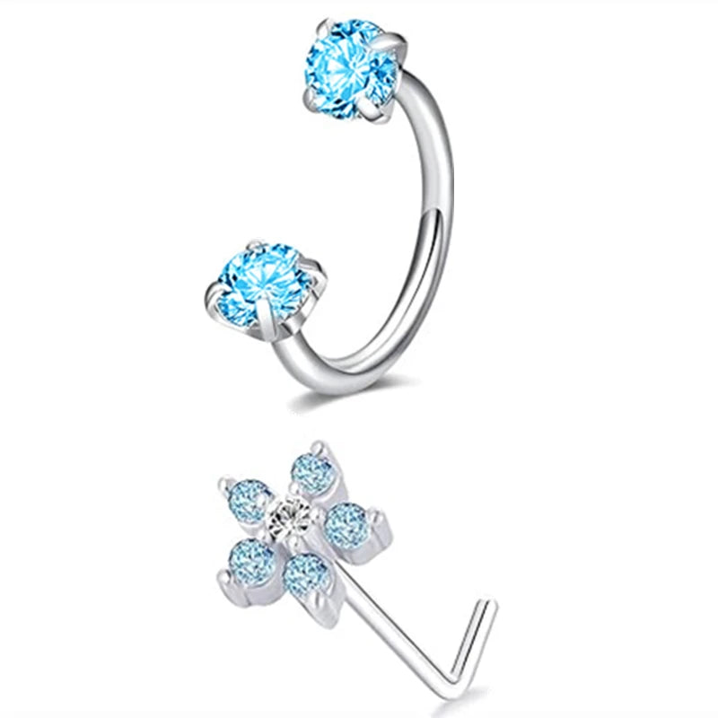 A set of silver horseshoe nose rings featuring round blue topaz stones.