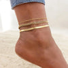 Gold stainless steel snake chain anklet worn on a woman's ankle.
