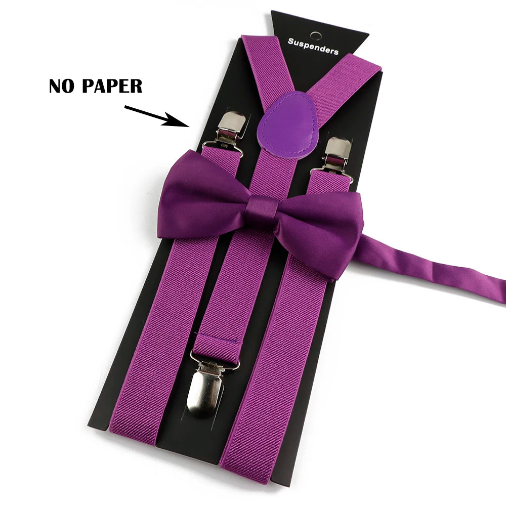 A set of purple polyester suspenders with bow ties displayed against a black background.
