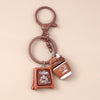 A brown leather coffee cup keychain with a hanging loop and charm.