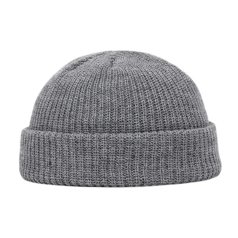 A gray knitted beanie cap with a ribbed cuff shown from the front.