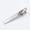 Silver metal tie clip for men's neckties with an engraved design.