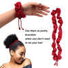 A hand is shown using red satin scrunchies as bracelets, with a woman wearing a braided hairstyle.