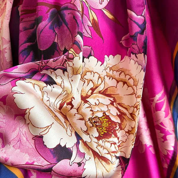 Close-up of a pink floral maxi kaftan dress fabric featuring large cream and purple roses.