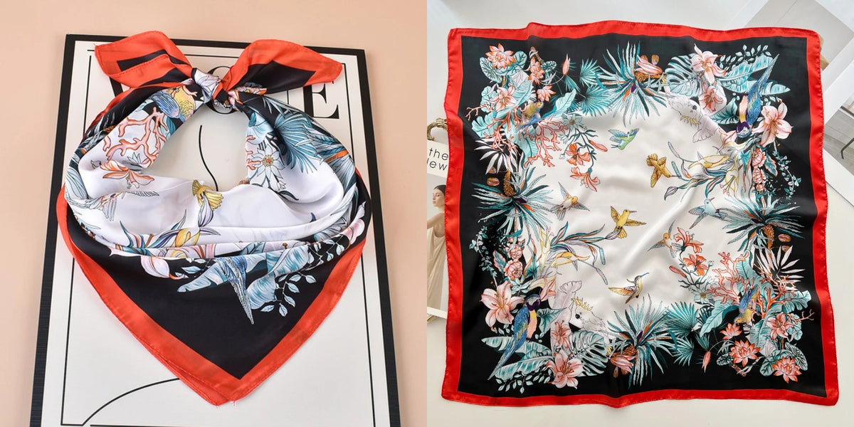 A floral print silk scarf featuring teal and pink botanicals on a black background.