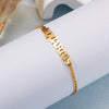 Gold stainless steel charm bracelet with the name Marcus engraved on it, shown on a wrist.