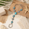 Silver beaded necklace and bracelet set featuring turquoise stones on a natural background.