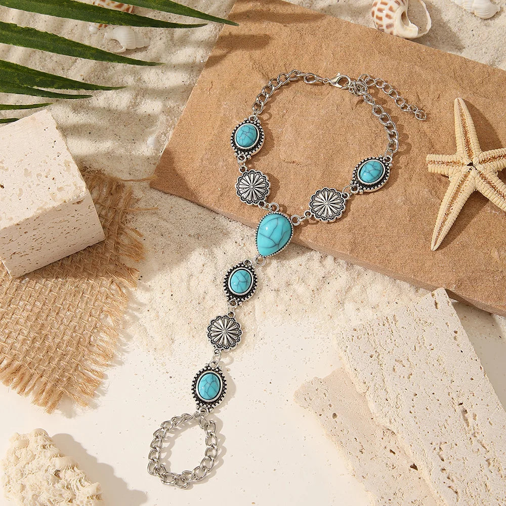 Silver beaded necklace and bracelet set featuring turquoise stones on a natural background.