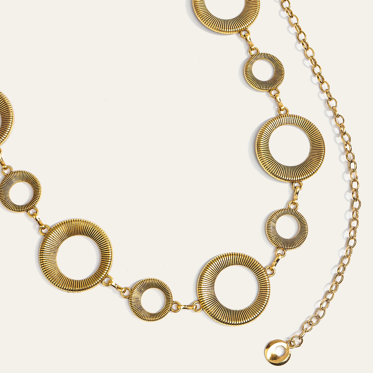 Zarte goldene Metallgürtelkette mit einer Reihe konzentrischer Ringe und Glieder.