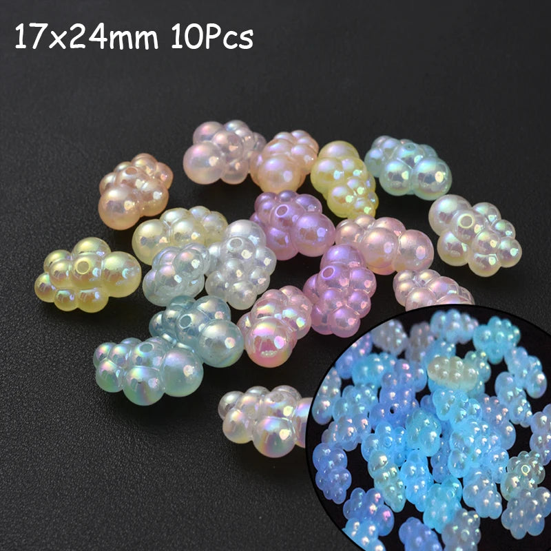 A collection of 10 iridescent glow-in-the-dark acrylic beads in various shades of pink, purple, and yellow.