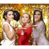 Three smiling girls wearing tiara crowns posing against a sparkling gold background