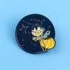A dark blue enamel pin featuring a cute firefly character with large eyes and wings.