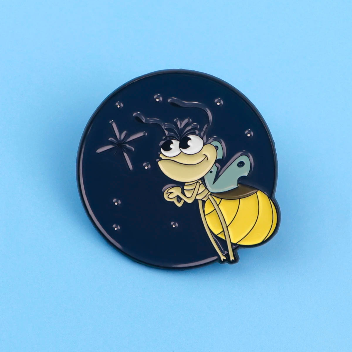 A dark blue enamel pin featuring a cute firefly character with large eyes and wings.