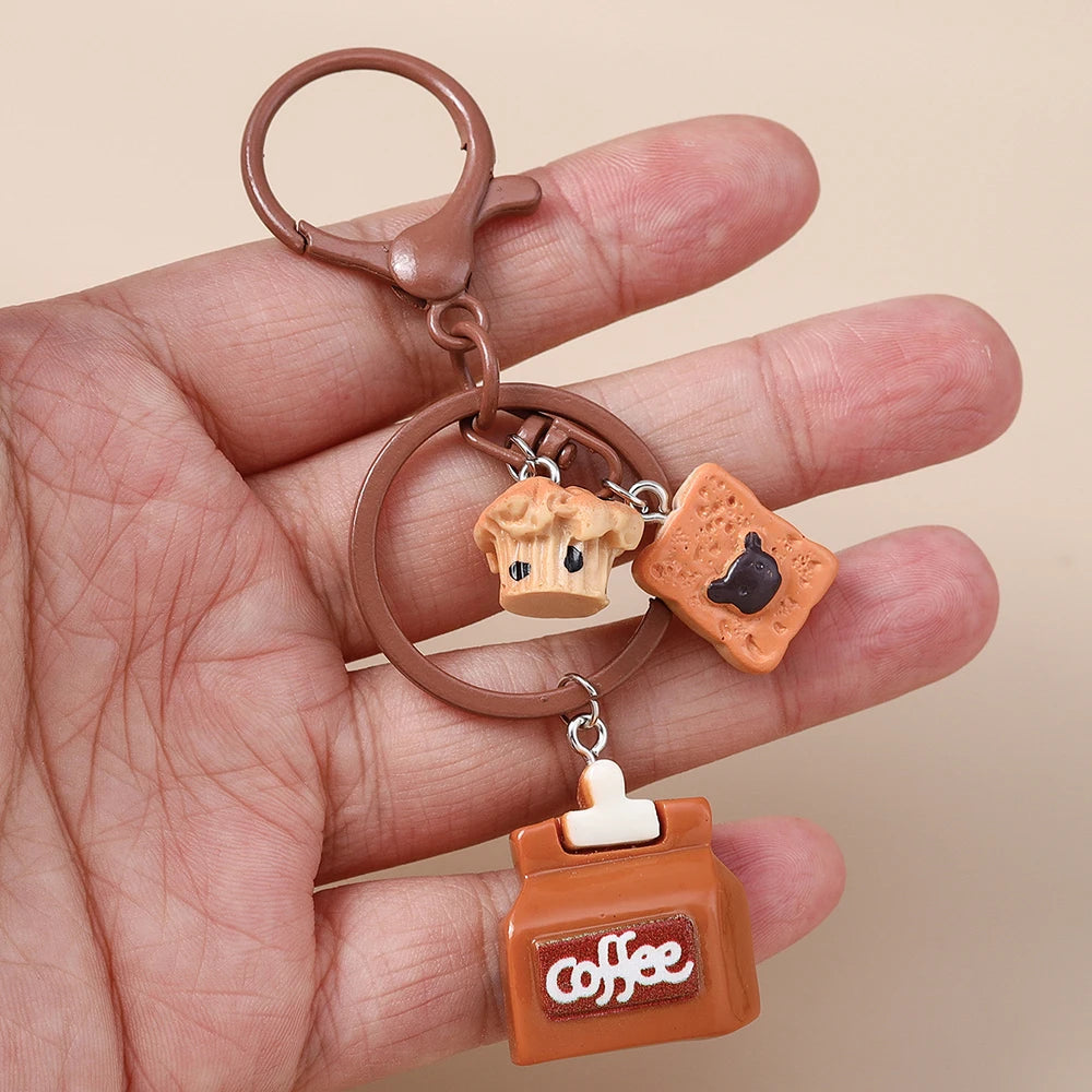 A brown leather keychain featuring a coffee pot charm, held in a person's hand.