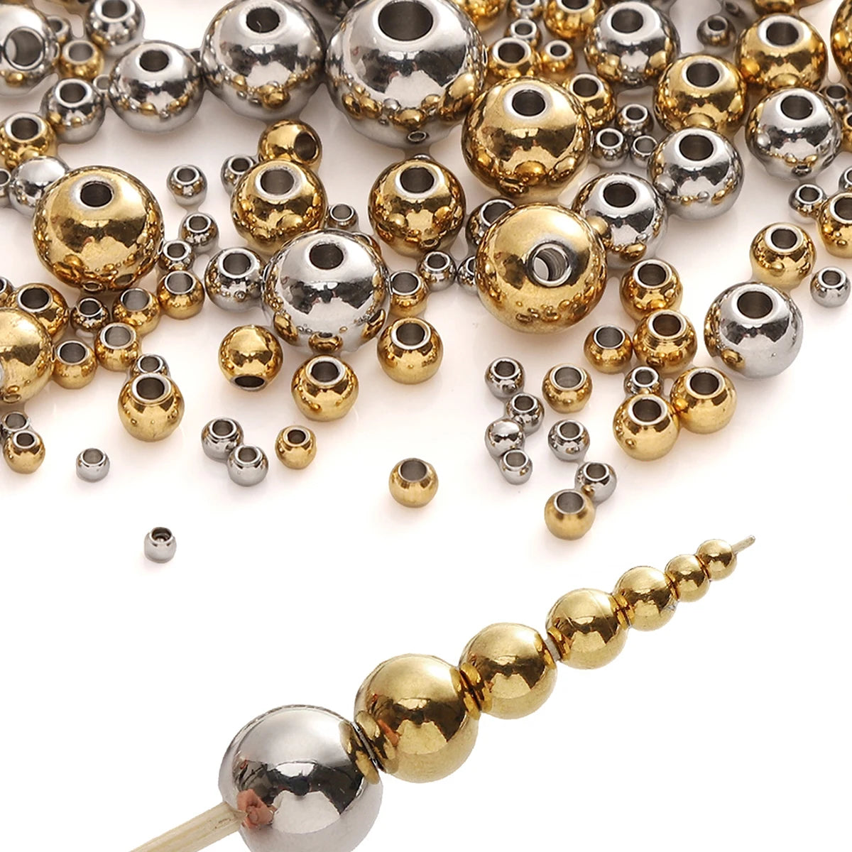 A collection of silver and gold spacer beads for DIY jewelry making, including round and barrel shapes.